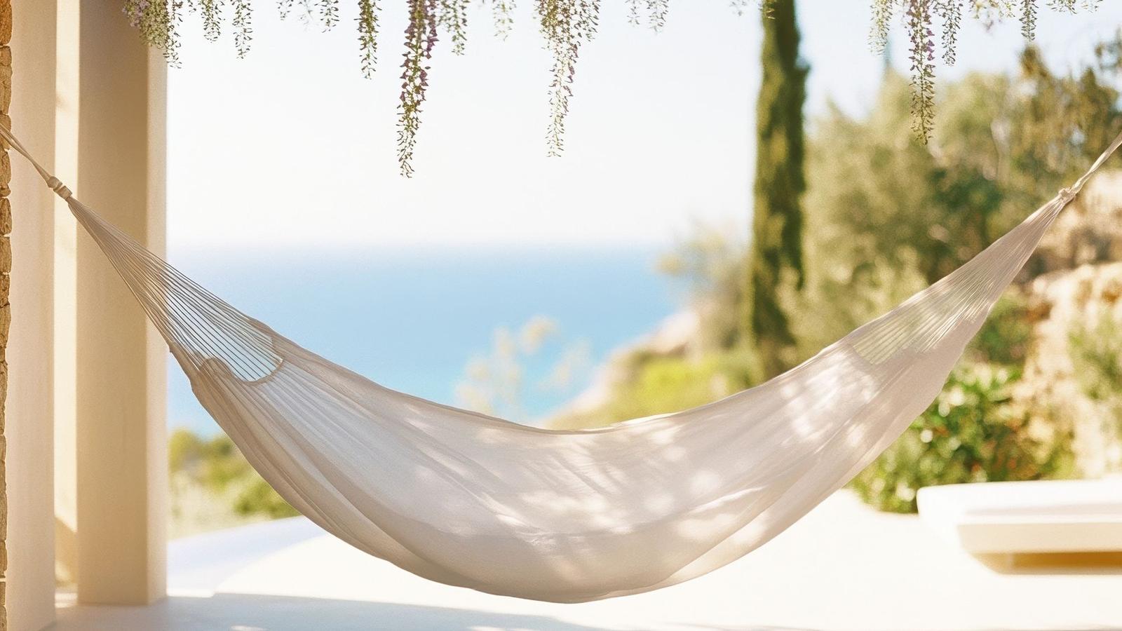 A white hammock on a shaded terrace above the sea